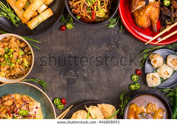 Chinese food dark background. Chinese noodles,\
fried rice, dumplings, peking duck, dim sum, spring rolls. Famous\
Chinese cuisine dishes set. Space for text. Top view. Chinese\
restaurant concept