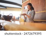 Chinese food, waitress and an asian woman in a sushi restaurant to serve a traditional meal for nutrition. Kitchen, smile and cooking with a happy young employee in an eatery for fine dining cuisine