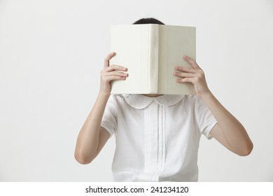 Chinese Girl Holding A Blank Cover Book Covering Her Face