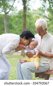 Chinese Grandfather And Grandmother Playing With Baby Grandson At Outdoor