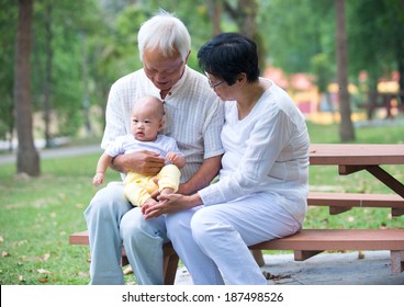 chinese grandfather playing with baby grandson at outdoor