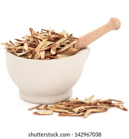 Chinese Herbal Medicine Of Licorice Root In A Stone Mortar With Pestle Over White Background.