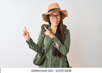 Chinese Hiker Woman Wearing Canteen Hat Glasses Backpack Over Isolated White Background Smiling And Looking At The Camera Pointing With Two Hands And Fingers To The Side.