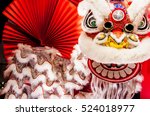 Chinese lion dance for Chinese new year with red fan in the background