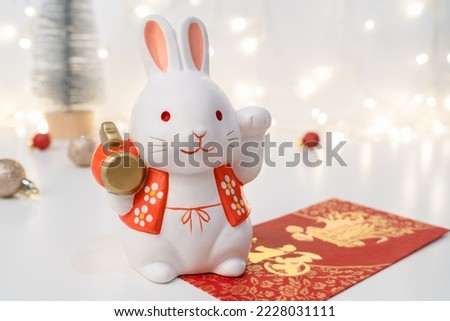 Chinese Lunar New Year concept. Greeting for Chinese Rabbit New Year with red envelope. The Chinese word means happiness or good fortune. 