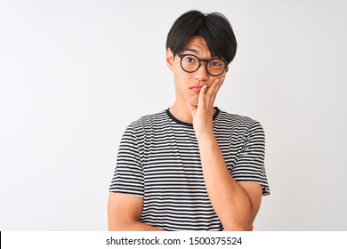 Chinese Man Wearing Glasses And Navy Striped T-shirt Standing Over Isolated White Background Thinking Looking Tired And Bored With Depression Problems With Crossed Arms.