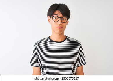 Chinese Man Wearing Glasses And Navy Striped T-shirt Standing Over Isolated White Background Depressed And Worry For Distress, Crying Angry And Afraid. Sad Expression.