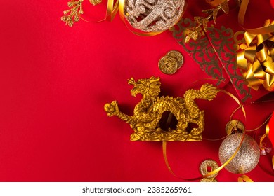 Chinese New Year 2024 greeting card. Bright red asian year of the dragon background with golden dragon figurine, Chinese lanterns, traditional jewelry, gifts, coins, cookies with wishes, copy space - Powered by Shutterstock