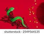 Chinese New Year 2025 background, year of the green Snake. Chinese Lunar New Year greeting card, flat lay with green snake on top with space for text, invitation, promotion, flat lay.