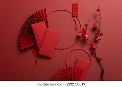 Chinese New Year background with paper fans, lucky envelopes, flower branches, and lucky ornaments. Asia holiday - Shutterstock ID 2232780519
