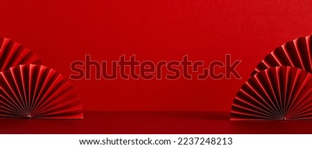 Chinese New Year celebration concept. Banner design with red paper fans decorations on red background with copy space.