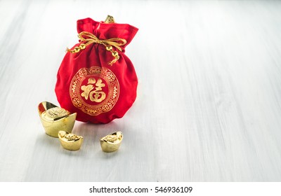 Chinese New Year Decoration,red Fabric Packet Or Ang Pow With Chinese Style Pattern And Golden Ingots On Wood Table Top, Chinese Language Mean Happiness,Leave Space For Add Text