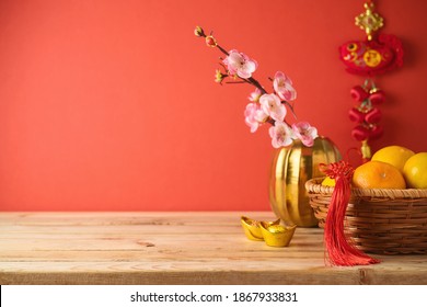 Chinese New Year Decorations On Wooden Table Over Red Background