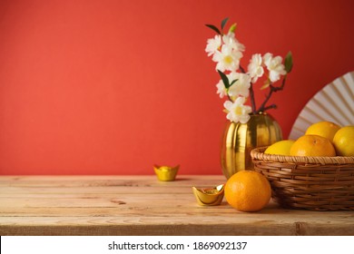 Chinese New Year Decorations On Wooden Table Over Red Background