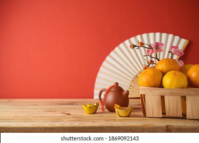 Chinese New Year Decorations On Wooden Table Over Red Background