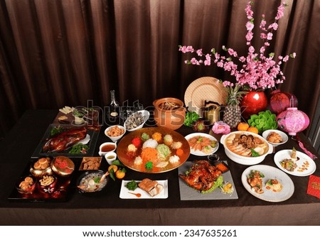 chinese new year festival asian food cuisine with meat, vegetable, noodle, cookies and yusheng lo hei with sakura flower lantern decoration on bronze background restaurant banquet halal dining menu	