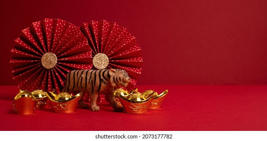 Chinese New Year Festival Decoration Over Red Background. Traditional Lunar New Year Gold Ingots, Paper Fans. Copy Space, Banner