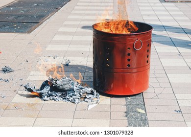 Chinese New Year festival with fire burning silver and gold paper fake, Burn the gods paper in red metal bucket with ashes