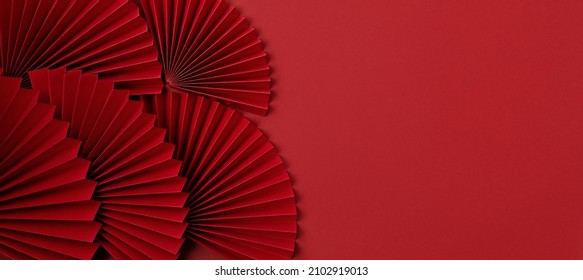 Chinese new year festival or wedding decoration over red background. Traditional lunar new year paper fans. Flat lay, top view, banner - Shutterstock ID 2102919013