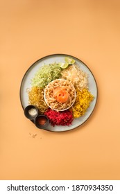 Chinese new year food and drinks, raw fish salad “Yusheng” on cream coloured background flat lay image.