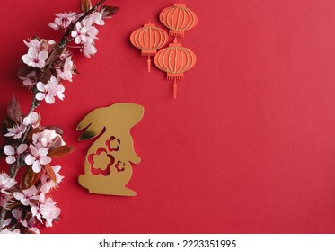 Chinese New Year, year of the rabbit. Year 2023 with golden rabbit and plum blossom fans. Copy space.