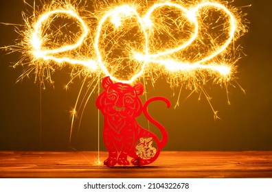 Chinese New Year of tiger 2022 mascot paper cut with 2022 written by fireworks on back, the Chinese means fortune no logo no trademark