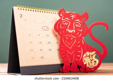 Chinese New Year of Tiger mascot paper cut and a 2022 calendar with the New Year day highlighted, the Chinese means Happy New Year no logo no trademark - Shutterstock ID 2104814408