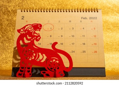 Chinese New Year of Tiger mascot paper cut and a 2022 calendar with the New Year day highlighted no logo no trademark