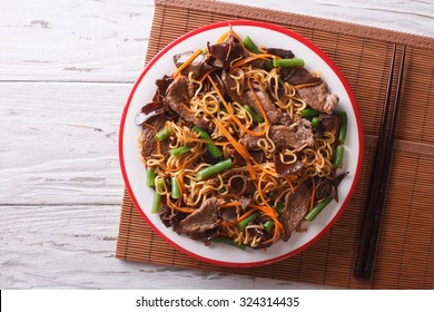 Chinese Noodles With Beef, Muer And Vegetables Close-up On A Plate. Horizontal View From Above
