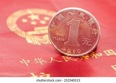 Chinese one yuan coin against the background of the Chinese passport