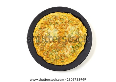 chinese pan fried egg flatbread with chopped green chili peppers on green ceramic plate