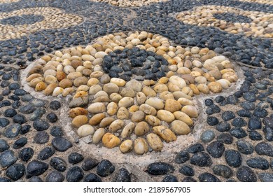 Chinese Pebble Decorative Walkway Of Artistic Designs And Mosaic. Reflexology Paths. Walking Path Made Of Smooth River Rocks Turned On Edge And Closely Packed Together, Embedded In Concrete Substrate.