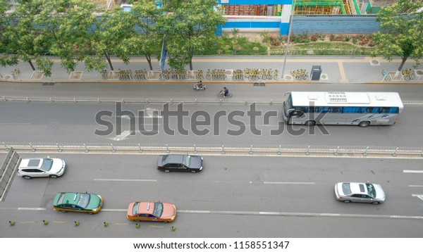 Chinese people ride bike,\
motorcycle, car, taxi and bus on the street top view, Beijing,\
China