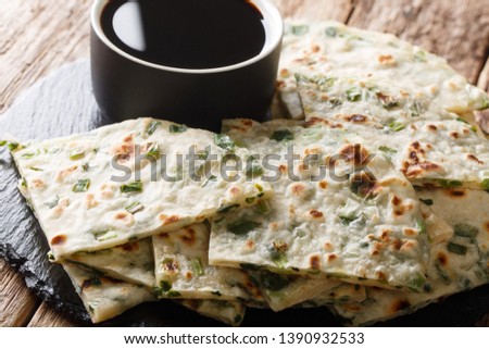 Chinese Scallions pancake also known as green onion pancake or congyoubing  close-up on a board on a table. horizontal
