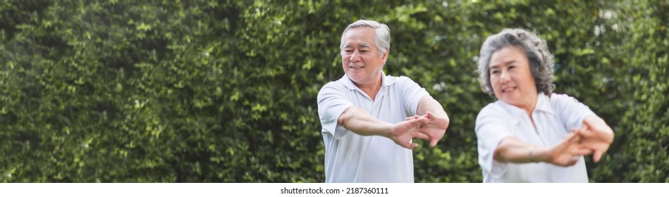 Chinese Senior Adult Man And Woman Stretching Hands And Arms Before Exercise At Park. Happy Elderly Couple Enjoying Workout At Outdoor