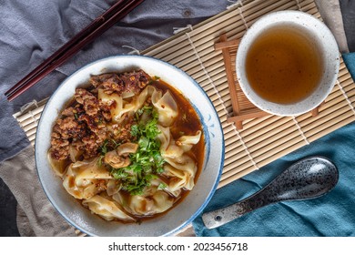 Chinese Sichaun Cuisine; Original Hot And Spicy Sichuan Pickled Chilli Oil Shrimp Wonton Soup With Green Onion And Tea Set In The Studio Lighting