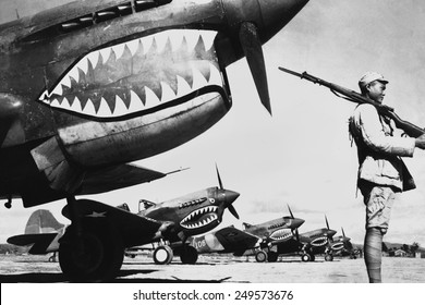 Chinese soldier guards a line of American P-40 fighter planes, ca. 1942. The shark-face fighters of the 'Flying Tigers' had a 12-to-1 victory ratio over the Japanese planes during World War 2.