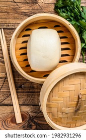 Chinese Steamed Buns in traditional bamboo steamer. Wooden background. Top view