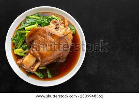 Chinese stewed pork knuckle leg in sweet brown sauce on dark tone texture background with copy space for text, top view, flat lay, Thai food, Ka Moo Pa Lo, Ka Moo Palo, Kha Moo Pa Lo, Kha Moo Palo