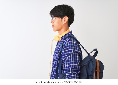 Chinese Student Man Wearing Backpack And Headphones Over Isolated White Background Looking To Side, Relax Profile Pose With Natural Face With Confident Smile.