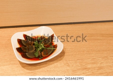 Chinese style chilly oil sauce preserved egg or can be called Alkalized or century Egg on a white plate with copy space