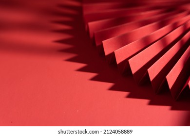 A Chinese Style Paper Folding Fan With Shadow Isolated On Red Background