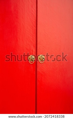 Chinese style wooden red door with lion heads.