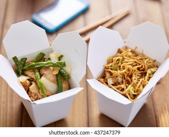 Chinese Take Out Food In Boxes Close Up With Mobile Phone In Background