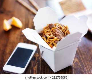 Chinese Take Out With Smart Phone On Table And Menu