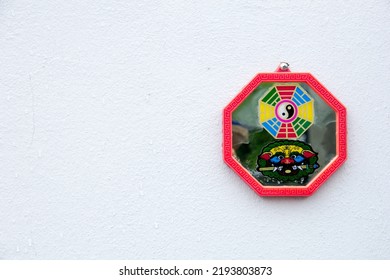 Chinese Talisman Octagon Amulet And Lion Sword Mounted On A White Wall,chinese Amulet.