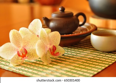 Chinese tea ceremony. Antique oriental tea pot with orchid flowers on wicker tray. Traditional asian tea set. Tea party. Teatime. beautiful teapot. Chinese kettle. Oriental culture. Taiwan. Relax