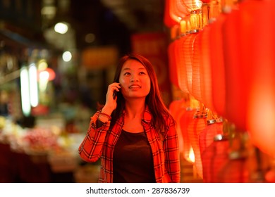 Chinese Teenager With Cell Phone Near Chinese New Year Lanterns