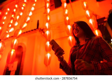 Chinese Teenager With Cell Phone Near Chinese New Year Lanterns