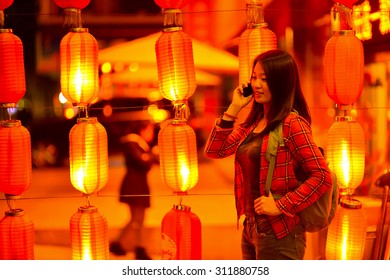 Chinese Teenager With Cell Phone Near Chinese New Year Lanterns